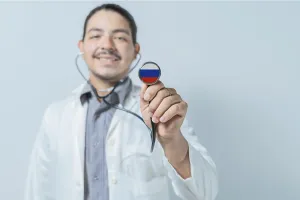 Smiling doctor showing stethoscope with Russia flag