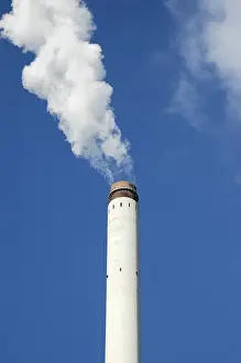 Smoking chimney in front of a blue sky