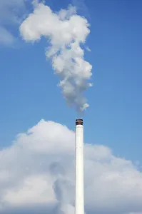 Smoking chimney in front of a blue sky