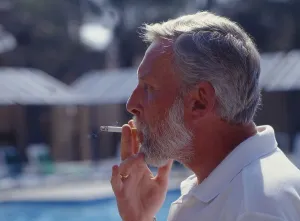 Smoking man, pulls on cigarette