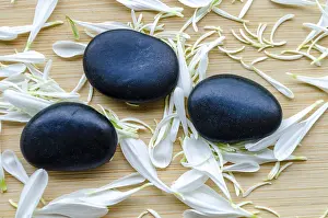 Three smooth zen stones in symmetrical layout against plain wooden background with customizable space for text