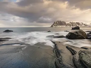 Smoothly polished rocks on Utakleiv beach in a dramatic cloudy atmosphere