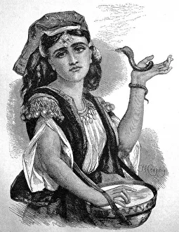 Snake tamer in Cyprus, young woman with a small snake and a drum at a performance