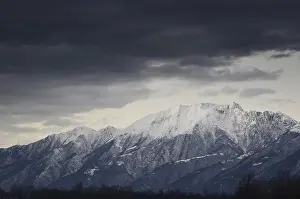 Snow-capped mountain with dark clouds