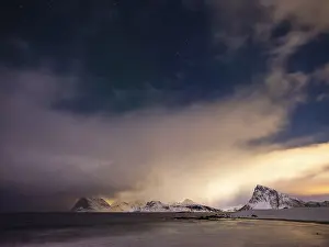 Snow-capped mountains on the coast at night