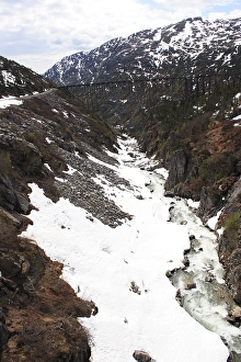 Snow capped mountains, A steel bridge constructed in 1901, tallest cantilever bridge in the world used until 1969, Skagway, Alaska, U.S.A. United States of America