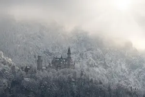 Snow-covered castle against an alpine backdrop