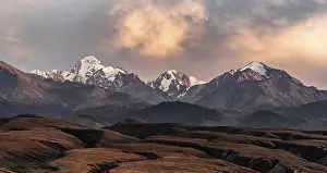 Snow-covered and glaciated mountain peaks at sunset
