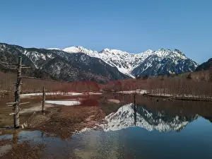 Snow-covered Japanese Alps reflected in Lake Taisho Pond