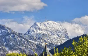 Snow-covered mountain peak under a blue sky with clouds