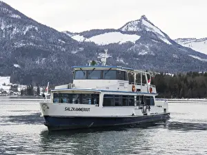 Snow-covered mountain peaks, excursion boat on Lake Wolfgangsee