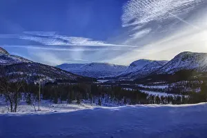 Snow-covered mountains and forests in the sunlight