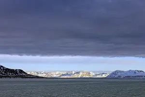 Snow covered mountains and glaciers debouching into Lilliehookfjorden