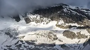 Snow-covered mountainside in fog