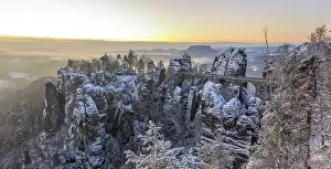 Snow-covered rock castle Neurathen and Bastei bridge in the morning