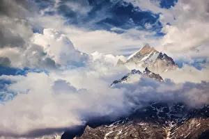 Snowcapped summit top of mountain in Himalayas in clouds