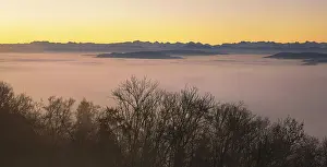 Snowy Alps over a sea of fog in morning light