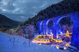 Snowy Christmas market under a railway viaduct