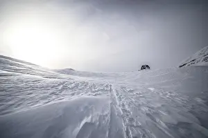 Snowy landscape with a lonely hut under a cloudy sky