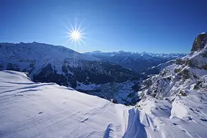 Snowy mountain landscape under a clear blue sky with bright sunshine