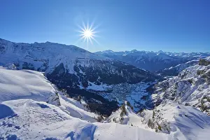 Snowy mountain landscape under a clear blue sky with bright sunshine