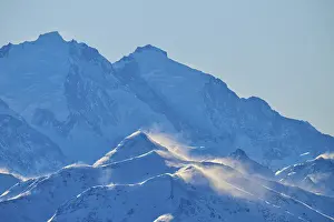 Snowy mountain peaks backlit with snow