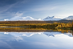Snowy mountains in Abisko National Park reflected in lake Vuolio Njahkajavri