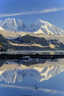 Snowy mountains reflected in fjord