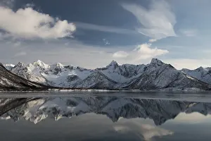 Snowy mountains reflected in water