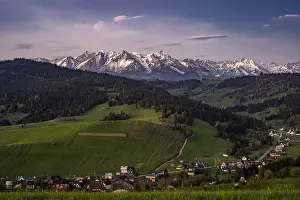 Snowy peaks, green meadows, mountain village
