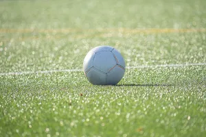 A soccer ball rests on a lush green soccer field