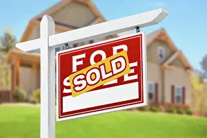 Sold Home For Sale Real Estate Sign in Front of Beautiful New House
