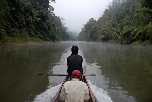 Solitary wooden boat floating upstream on the Nam Ou River