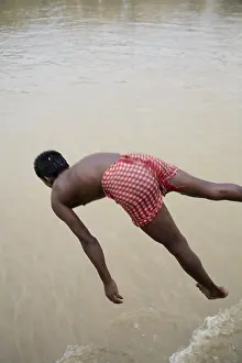 South Asian Indian boy jumping in the river Hooghly