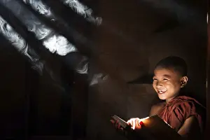 Southeast Asian little monk reading book inside monastery
