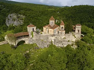 Spacious monastery structure on a rock surrounded by forest landscape