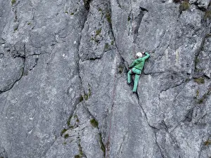 Sport climbing with rope, climber on a rock face