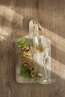 A sprig of white grapes, on a wooden board