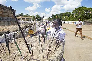 Sri Lankan pilgrim lighting incense sticks at the white stupa in the holy city of Anuradhapura