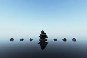 Stacked black stones with reflections on blue clean background