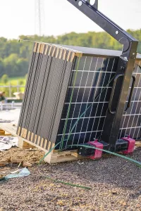 Stacked solar panels on pallets with lifting gear outdoors