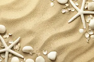 Starfishes, stones and seashells on sand background