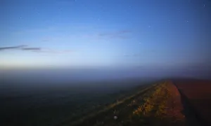 A starry sky over a deserted road at twilight