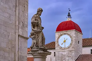 Statue of St John and the clock tower of the town loggia in Trogir