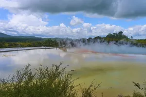 A steaming lake surrounded by bushes