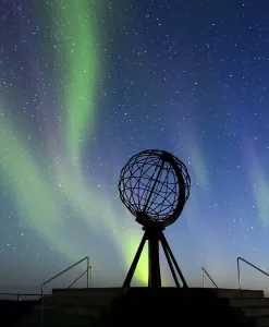 Steel globe at North Cape with northern lights