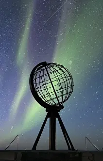 Steel globe at North Cape with northern lights