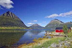 Steep mountains reflected in the water of a fjord