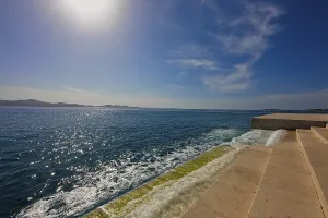 Steps lead to the clear sea under bright sunshine and blue sky