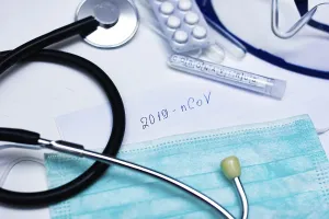 Stethoscope, mask, test tube labeled 2019 nCoV on a table